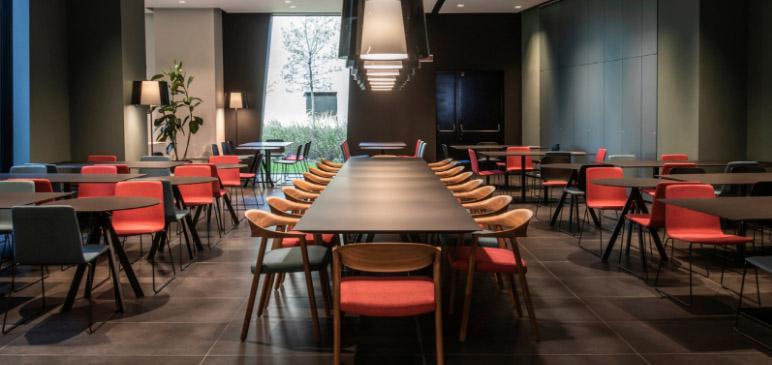 Sfeervolle inrichting bedrijfsrestaurant met tafels en stoelen Arki van Pedrali